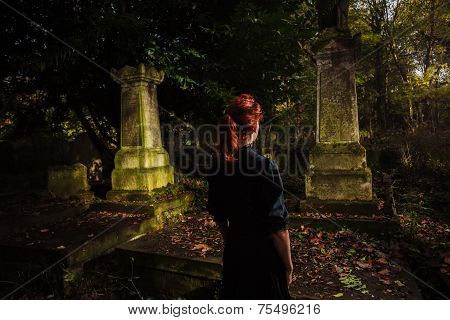 Young Redhead Woman Standing In Cemetery