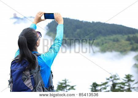 woman hiker taking photo at peak of emei mountain ,china