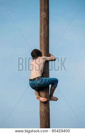 GOMEL, BELARUS - February 21, 2014 Young man climbs on a wooden
