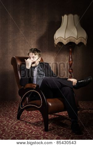 Elegant Teenage Boy Sitting In Arm-chair