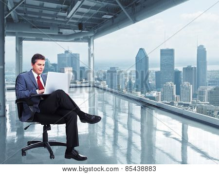 Businessman with laptop computer in the modern office. 
