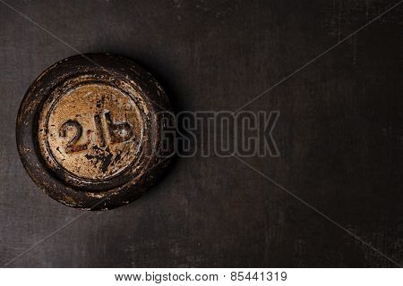 1lb pound vintage iron weight on metal backdrop