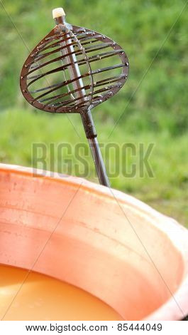 Steel Tool For Stirring The Milk In Big Copper Pot For Making Cheese