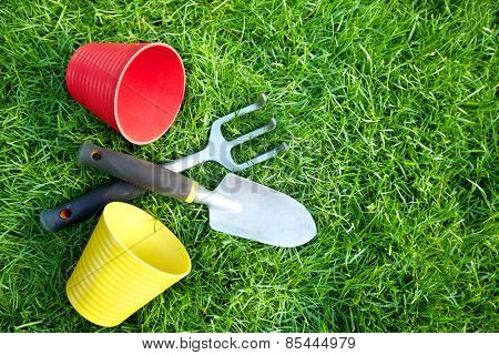 Gardening tools on green grass in the garden.