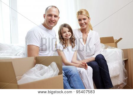family, children, accommodation and people concept - happy family with boxes moving to new home