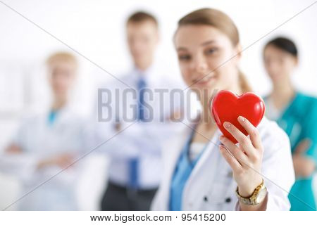 Female doctor with stethoscope holding heart .