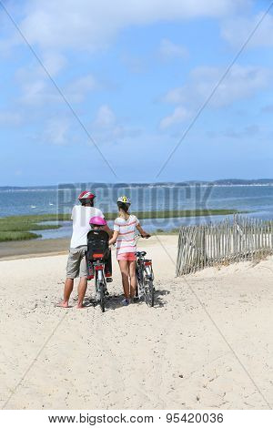 Family on a biking journey making a stop on the beach