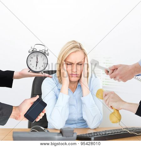 hand holding alarm clock against frustrated looking woman with eyes closed