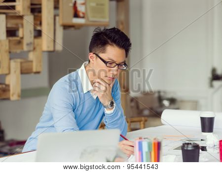 Young chineese engineer working in office