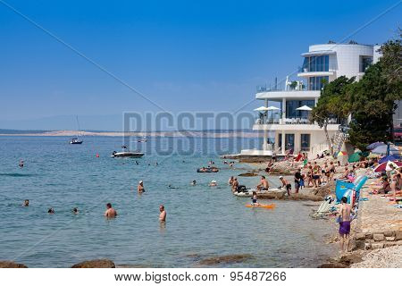 SELCE, CROATIA - JULY 04, 2015: People enjoying in swimming and sunbathing on the beach. Just a few steps from the Adriatic Sea, the modern-style Luxury Hotel Amabilis has a private beach. 