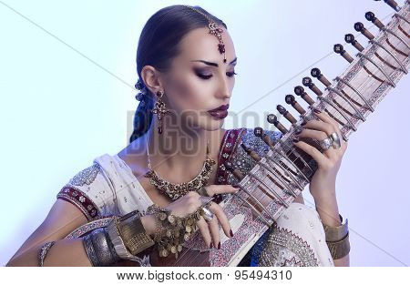 Beautiful Indian Woman In Sari With Oriental Jewelry Playing The Sitar