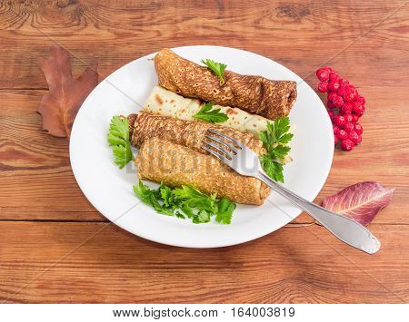 Pancakes filled with meat stuffing on white dish and fork