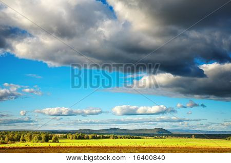 Krajina s hayfield a zamračená obloha