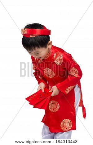 Little Vietnamese boy holding red envelops for Tet. The word mean double happiness. It is the gift in lunar new year or Tet Holiday on red isolate background.
