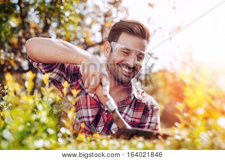 Portrait of a professional gardener.Young man working in garden.