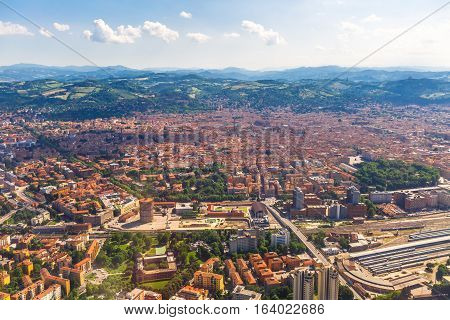 Aerial view of Bologna city in Italy with Asinelli Towers, San Luca Basilica church on Bologna hill and train station.