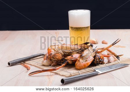 Burn Shrim And Seafood Sauce With Beer On Wooden Table.
