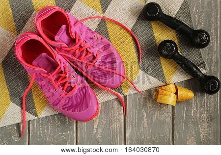 Trainers, dumbbells, ribbon, mat on floor. Stock photo Sporty mock up