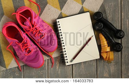 Trainers, dumbbells, ribbon, mat on floor. Stock photo Sporty mock up