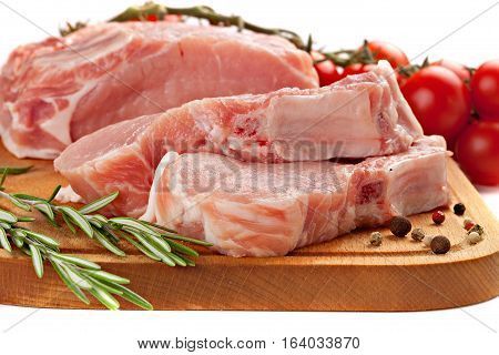 Fresh row pork with rosemary and spices on wood board isolated on white