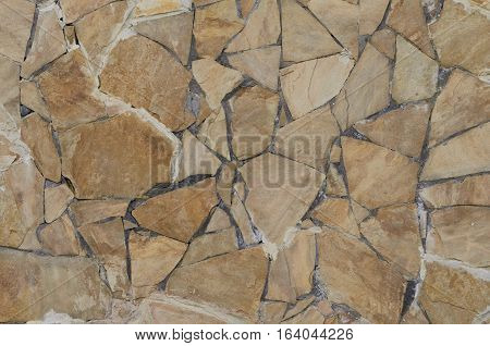 Background of a stone wall cladding texture brown stone bricks
