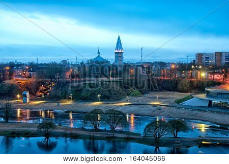 Narva. Estonia. Night view of the city with beach on Narova River and Alexander Lutheran Cathedral