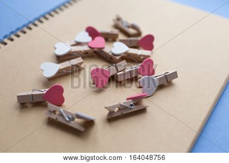 Clothespins with hearts are Notepad. Background is blue paper