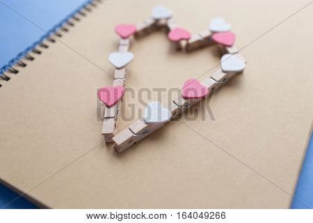 Clothespins with hearts are Notepad. Background is blue paper