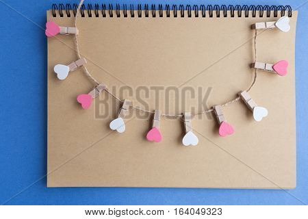 Clothespins with hearts are Notepad. Background is blue paper