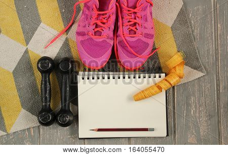 Trainers, dumbbells, ribbon, mat on floor. Stock photo Sporty mock up