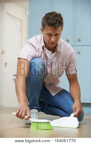 Man Sweeping Floor With Dustpan And Brush