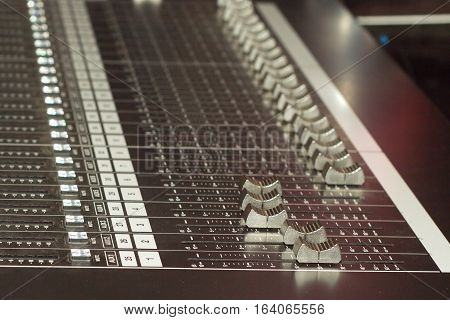 Big multichannel audio sound mixer with many buttons and sliders. Closeup view
