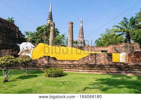 Buddha statues are white covered with yellow robe poses sleep amidst ancient ruins at Wat Yai Chai Mongkon temple in Phra Nakhon Si Ayutthaya Historical Park Ayutthaya Province Thailand