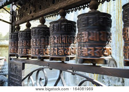 Spinning prayer wheels with mantra in buddha temple. Nepal