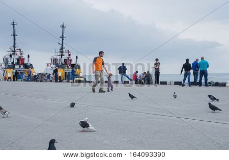 BATUMI GEORGIA - OCTOBER 9 2016: Unidentified people fishingresting and walking near the pier of Batumi.Batum is the second largest city of Georgia located on the coast of the Black Sea