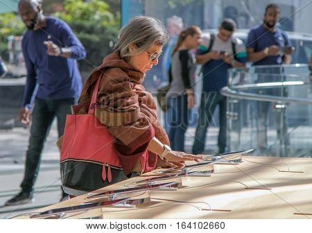 New York October 5 2016: An elderly woman is looking at an iPad tablet in the Apple store on Manhattan's Upper West Side.