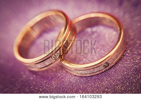 Two beautiful golden wedding rings with brilliants close-up. Selective focus