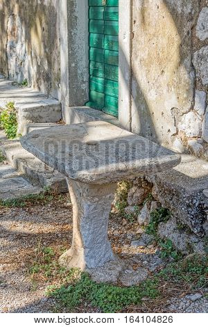 Old stone table in front of the typical house in Tucepi village in the slope of a mountain Biokovo.