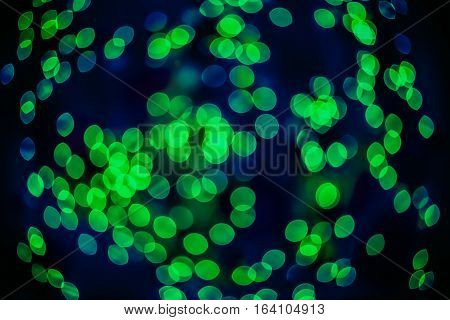 Bokeh background glowing oval shaped glow dark bright emerald green empty