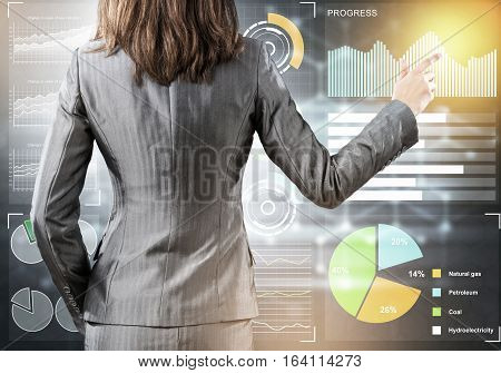 Rear view of businesswoman working with virtual panel interface