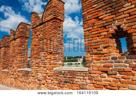 VERONA, ITALY- September 08 2016: The fortifications and battlements of Scaligeri Bridge (Ponte Scaligero) are made of bricks stretching over the river Adige now only used as a pedestrian walkway. Ponte Scaligero (Castelvecchio Bridge) is built in the sec