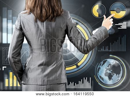 Rear view of businesswoman working with virtual panel interface