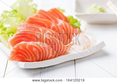 Salmon Sashimi On White Dish And Wood Background