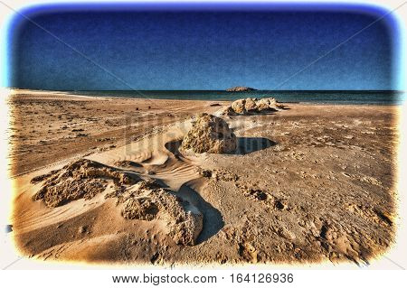 View of a small island from the Israeli shore of the Mediterranean Sea. Sand blowing over beach dune in wind in Israel. Vintage Style Toned Picture