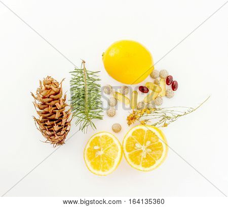 picture of a lemons pine twigscone herbal pills stjohn worth and omega 3 caspules on white background
