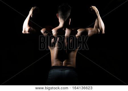 Muscular Man Flexing Muscles In Gym