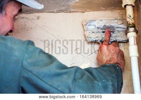 Man plastering wall with spatula. Wall finish 1