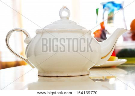 White ceramic teapot on the white table
