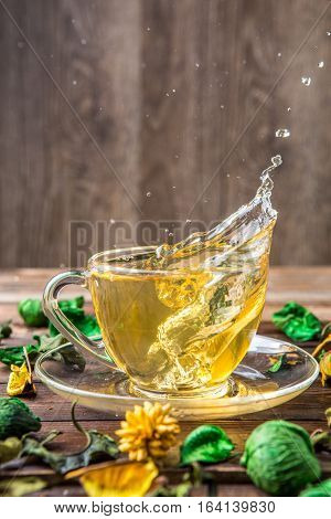 Green tea in transparent mug with spill dropwise