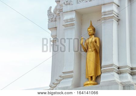 Golden buddha statue on the white pagoda.